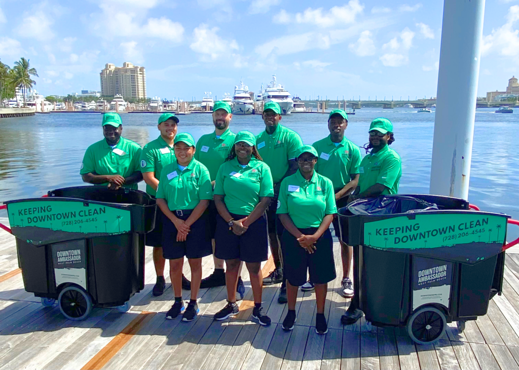 A team of Ambassadors in green shirts stand in front of a bay.